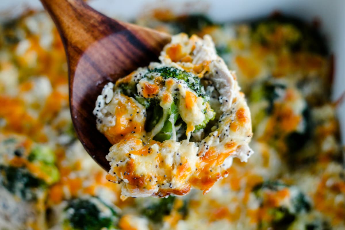 A spoon scooping everything bagel chicken casserole from a dish.