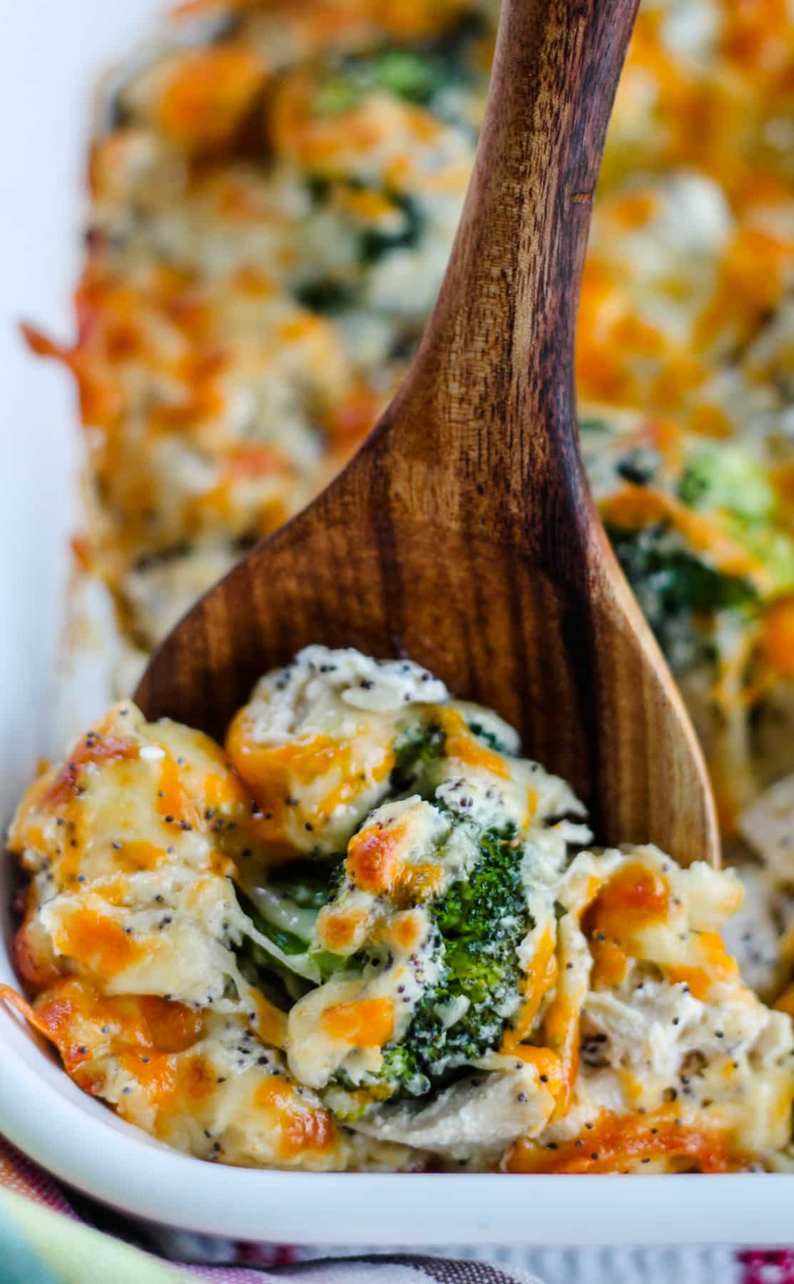 A spoon scooping everything bagel chicken casserole from a dish.