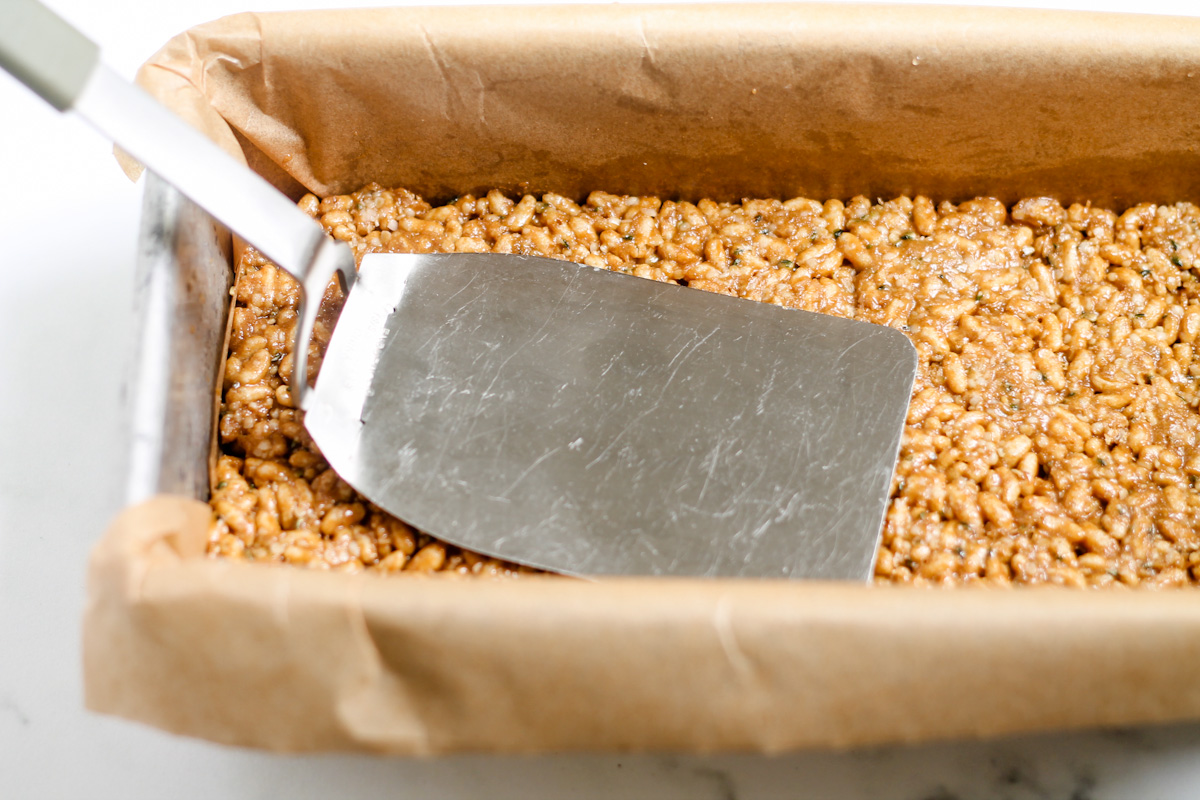 A spatula flattening ingredients in a pan.