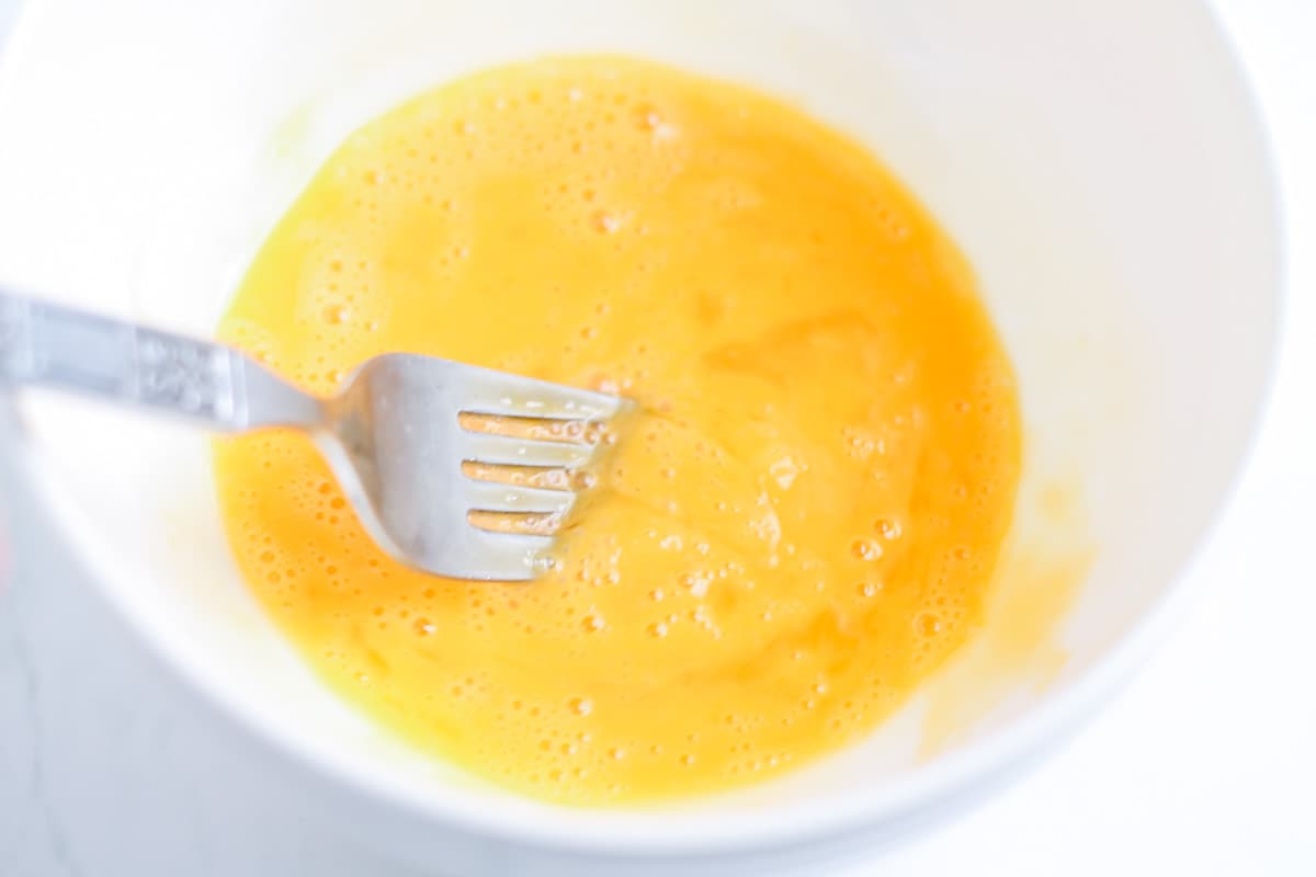 Eggs being whisked in a bowl.
