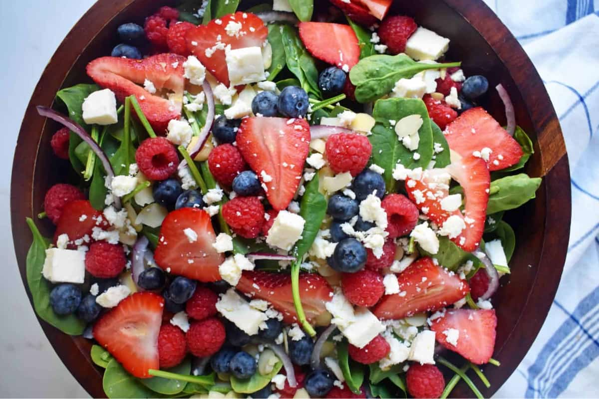 A bowl of Spinach Berry Salad with Sweet Poppy Seed Dressing.