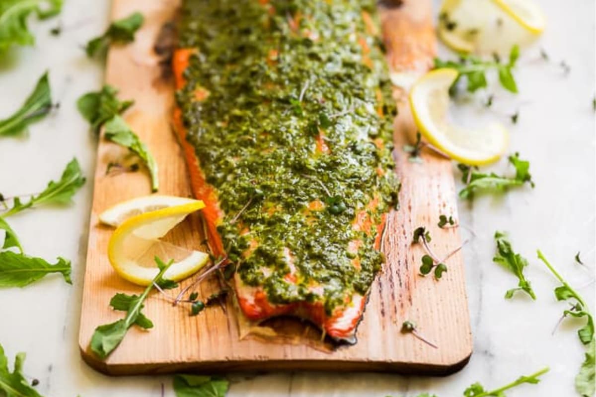 A platter of Cedar Plank Grilled Salmon with Herb Chimichurri.