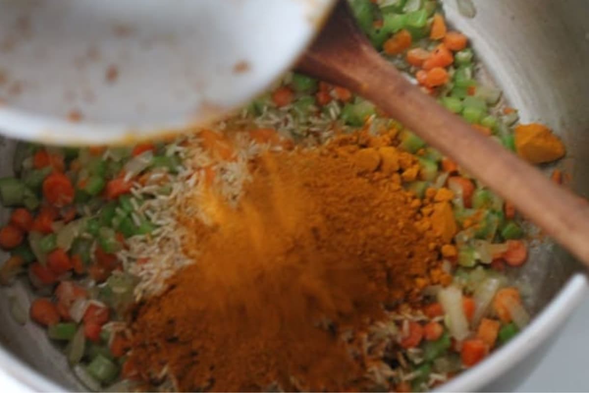 Spices being added to a pot.