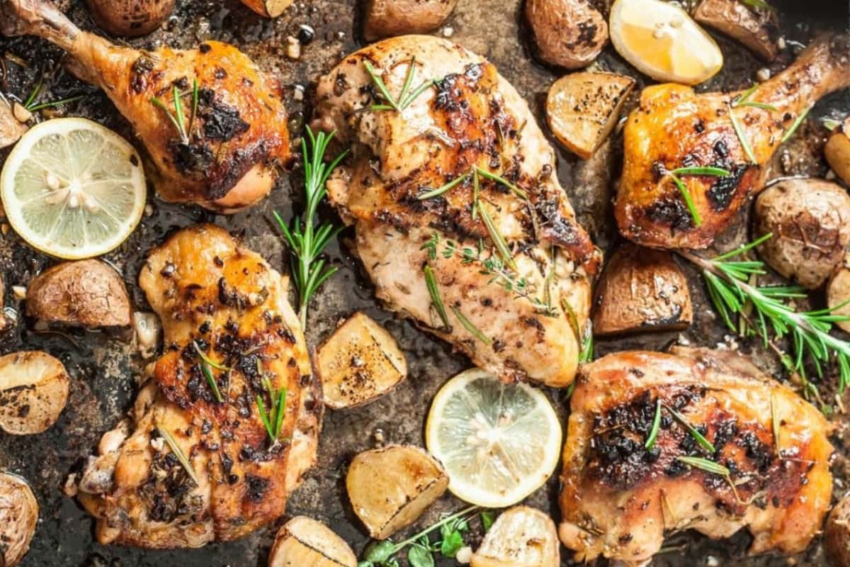 A tray of Sheet Pan Roasted Greek Chicken with Garlic Potatoes.