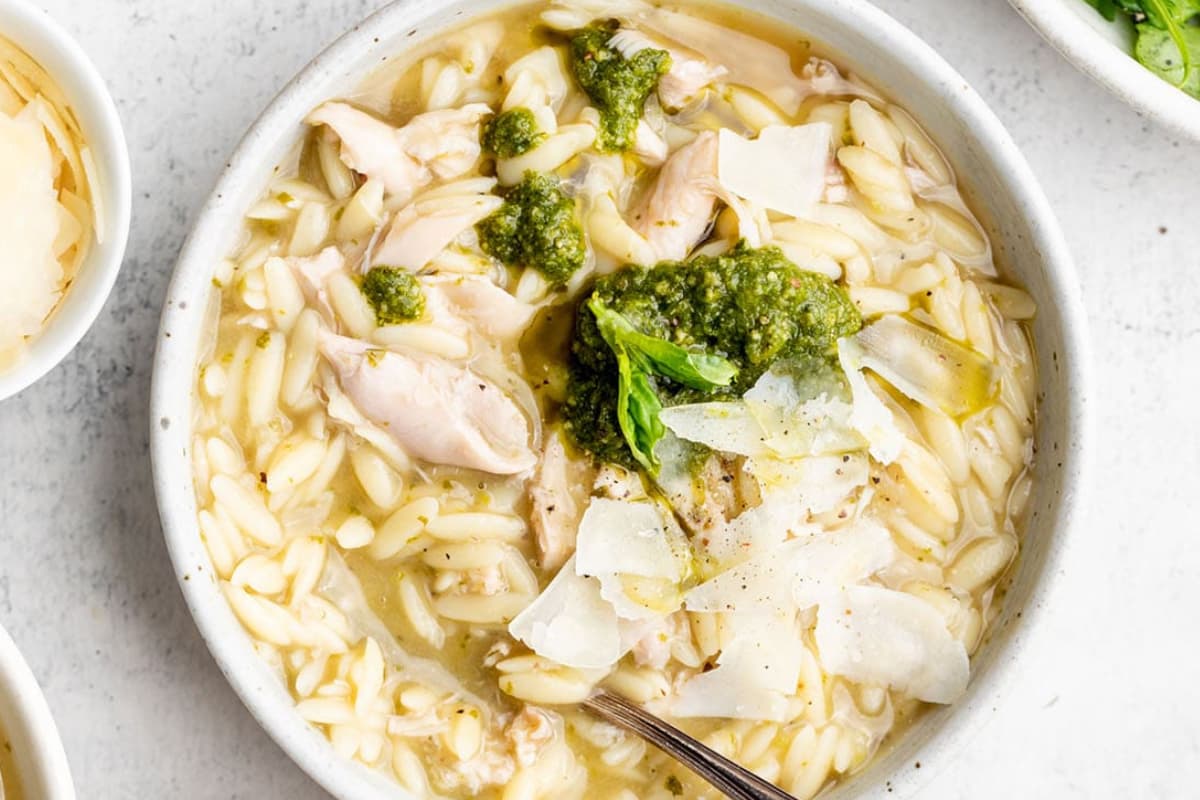 A bowl of Pesto Chicken Orzo Soup.