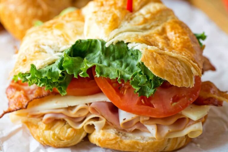 A plate of California Club Croissant Sandwich.