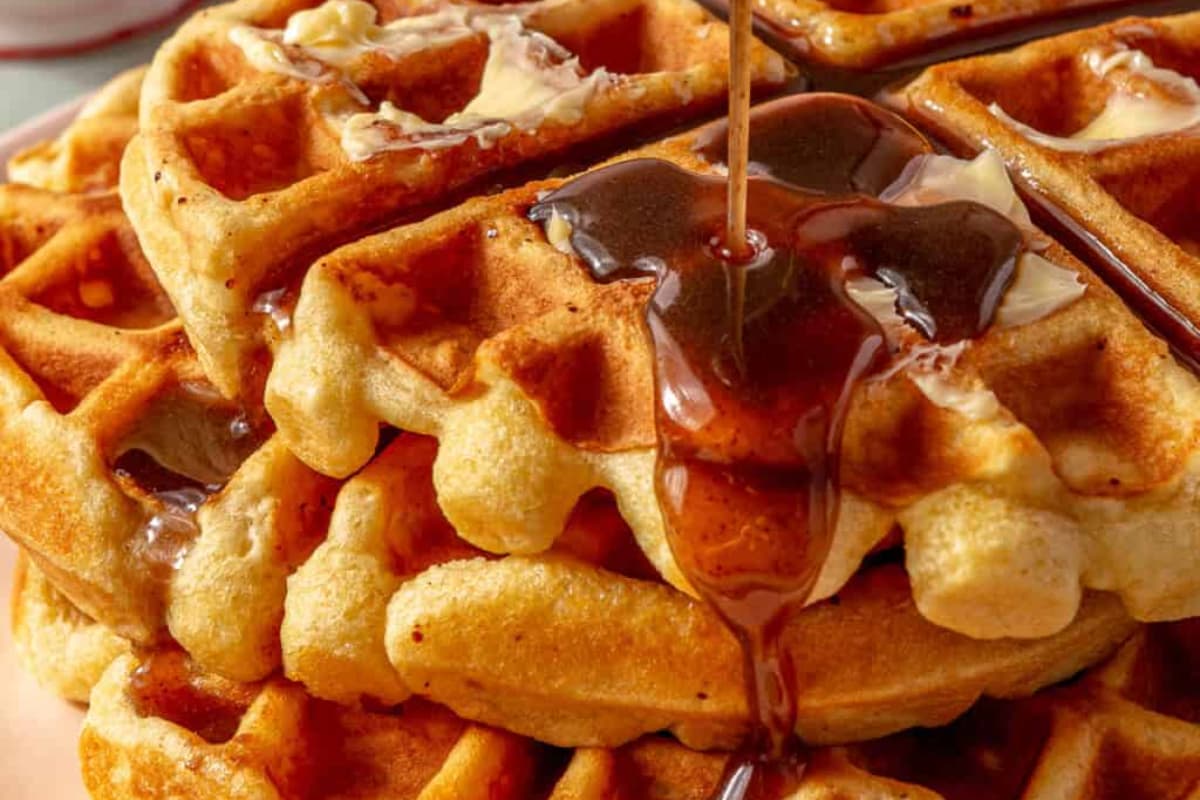 A plate of Eggnog Waffles with Cinnamon Syrup.