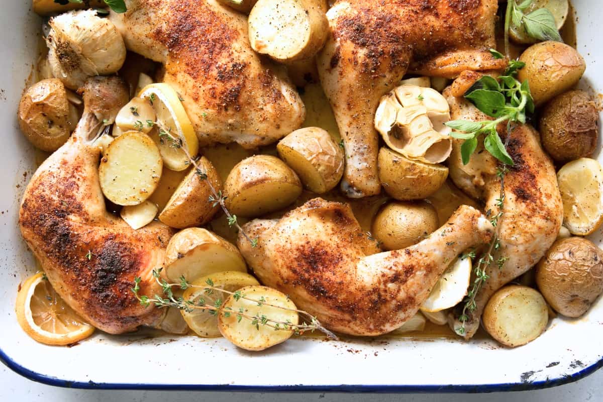 A dish Crispy Oven Roasted Chicken Legs with Potatoes.