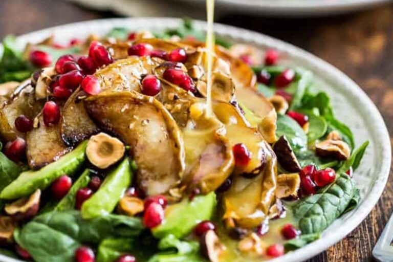 A plate of Roasted Pear Spinach Salad with Hazelnuts.