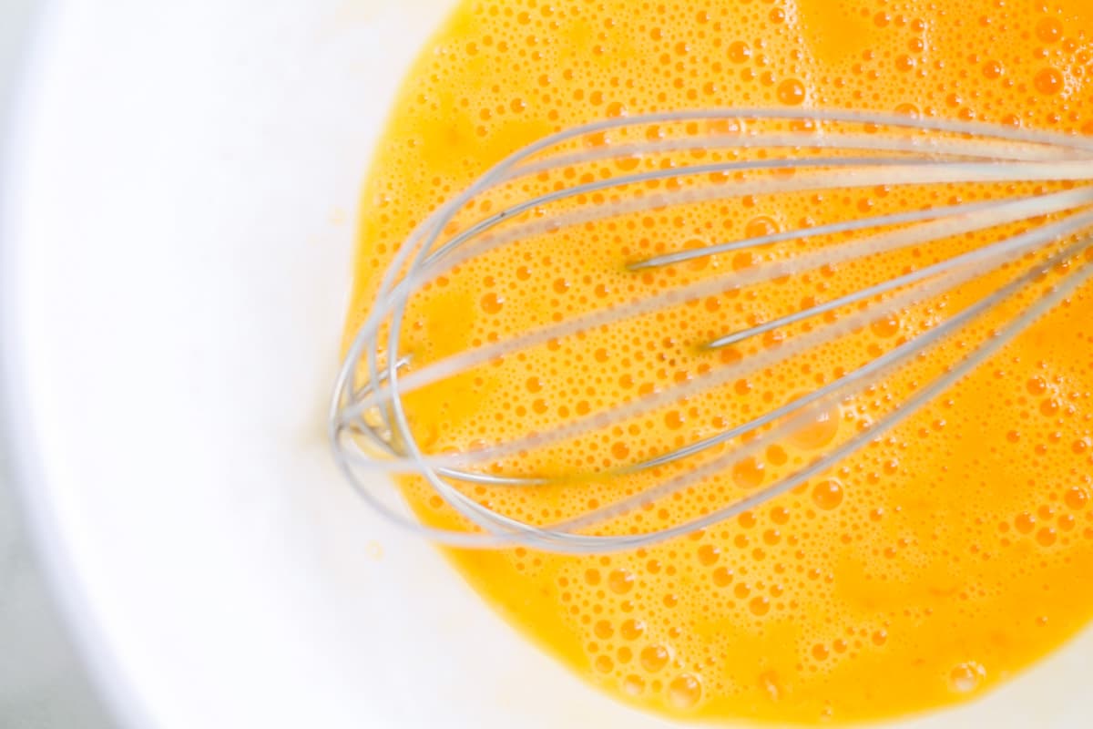 Eggs being whisked in a bowl.