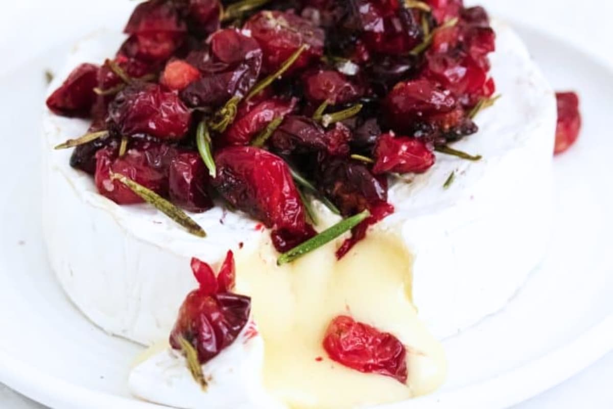 A plate of Warm Baked Brie with Roasted Cranberries.