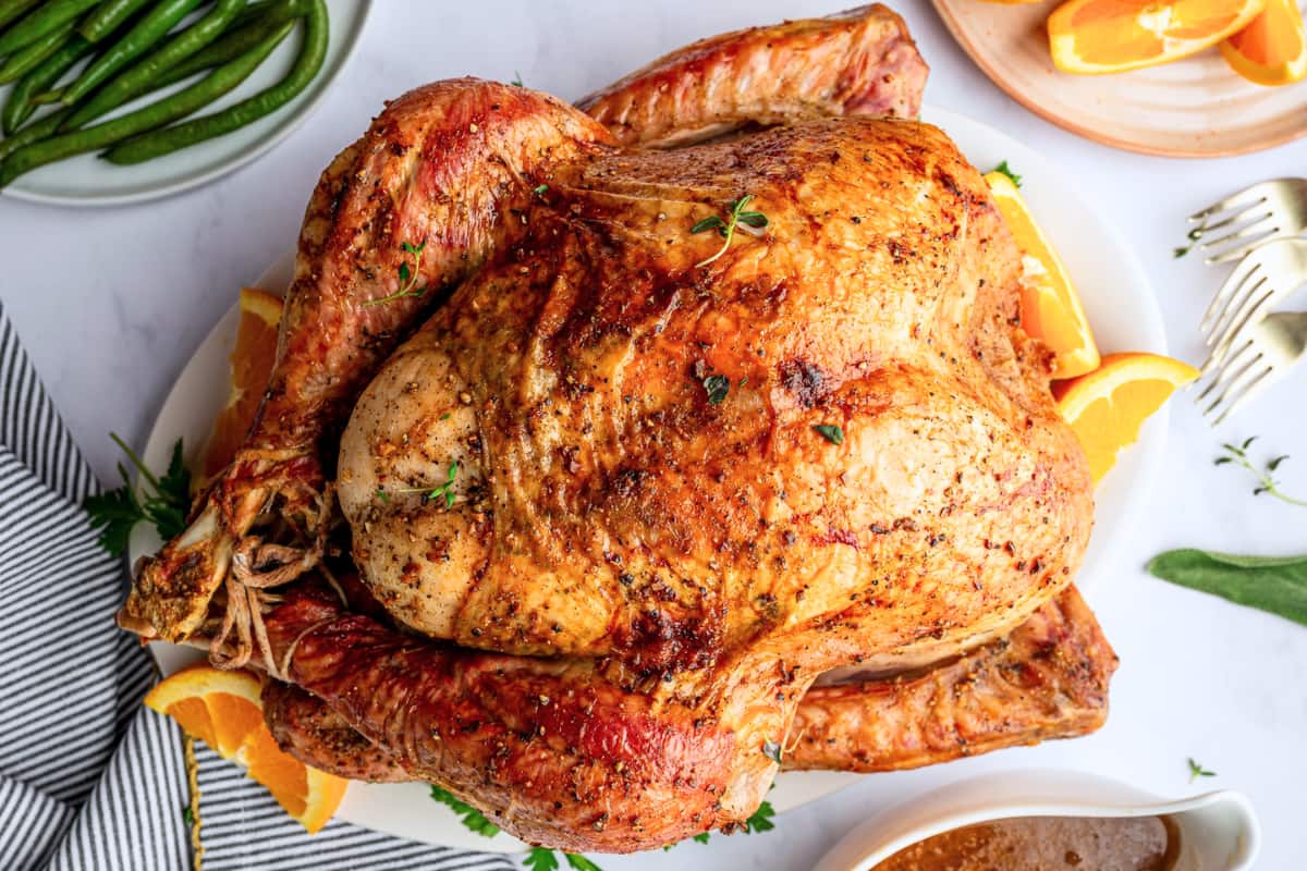 A table topped with a roasted turkey.