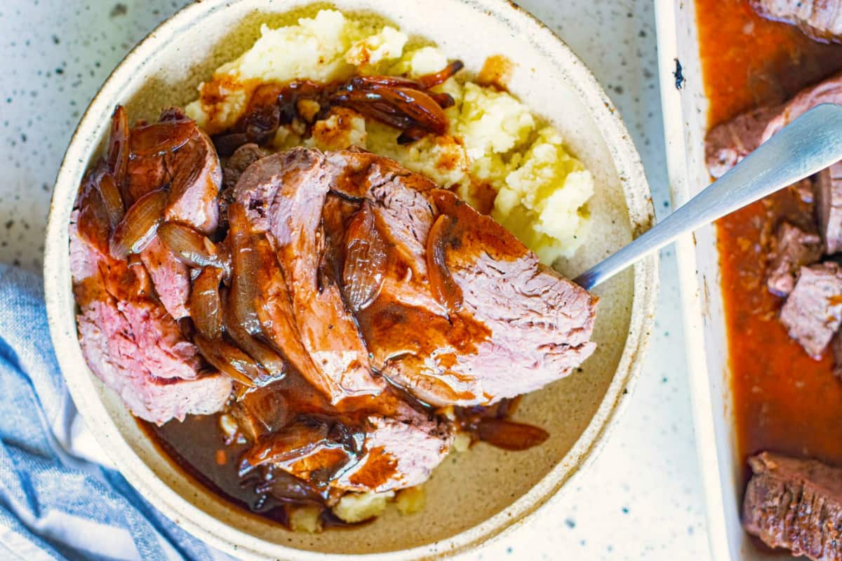 A plate of Roast Beef Tenderloin Recipe with Red Wine Sauce.