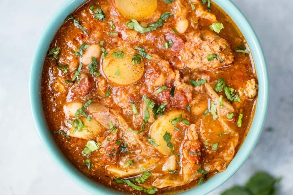 A bowl of Crockpot Cabbage Soup with Beans, Sausage, and Potatoes.