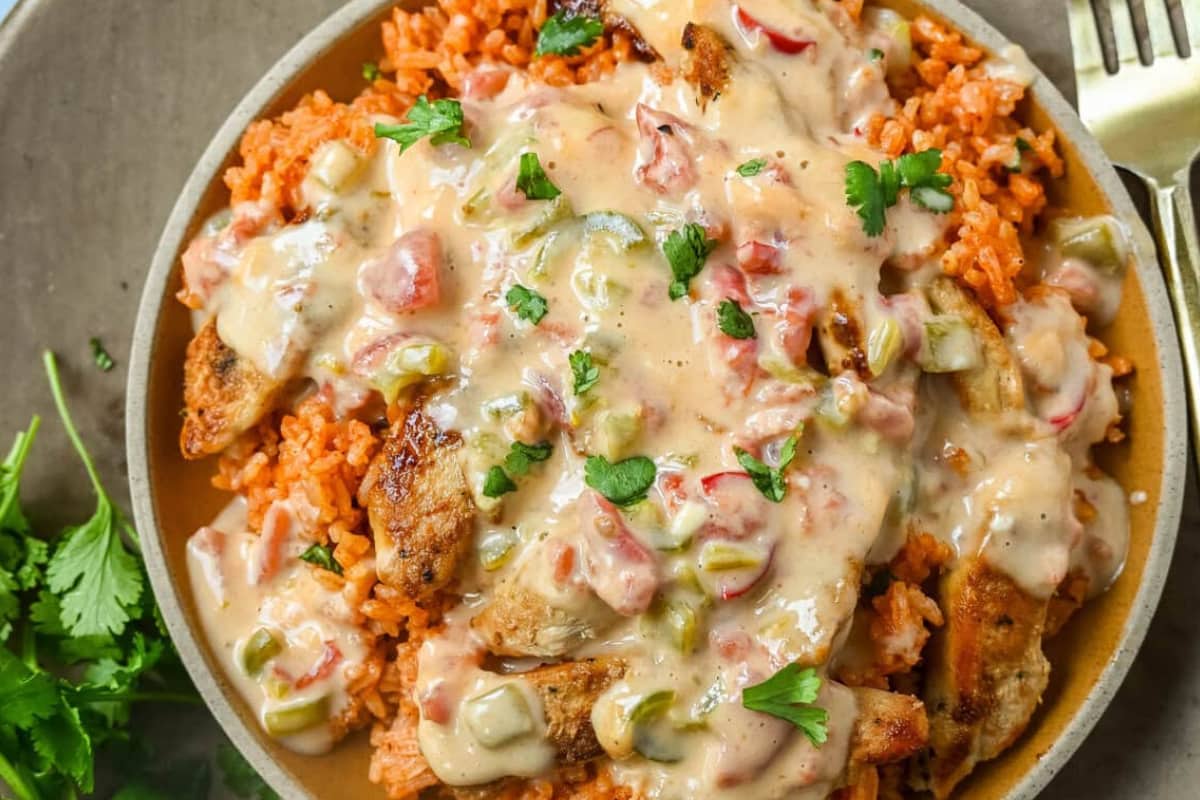 A dish of Queso Smothered Chicken and Rice.