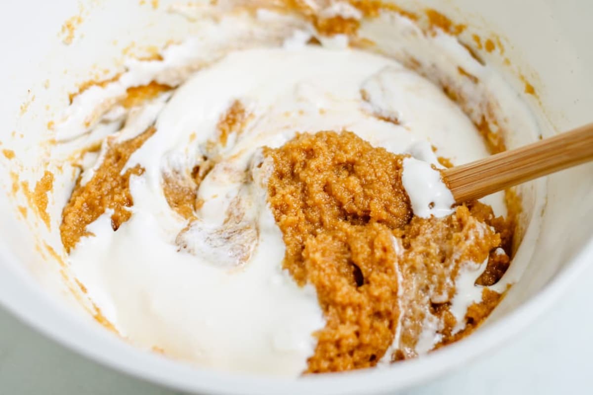 Sour cream being stirred into the batter.