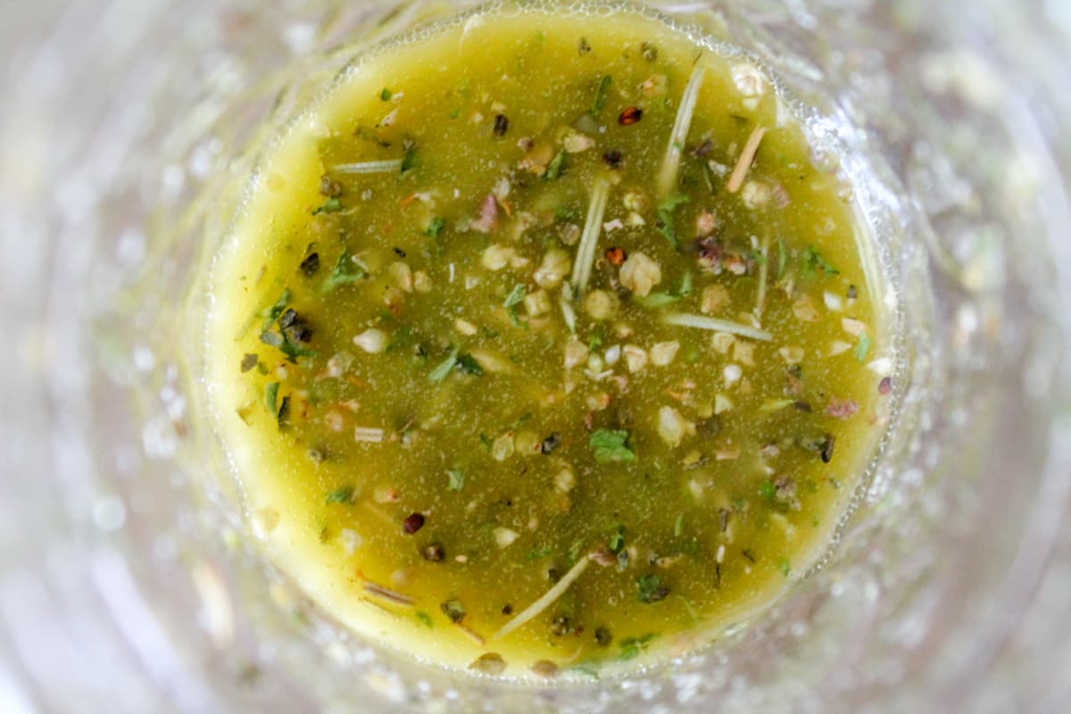 A jar of homemade Italian dressing after being shaken.