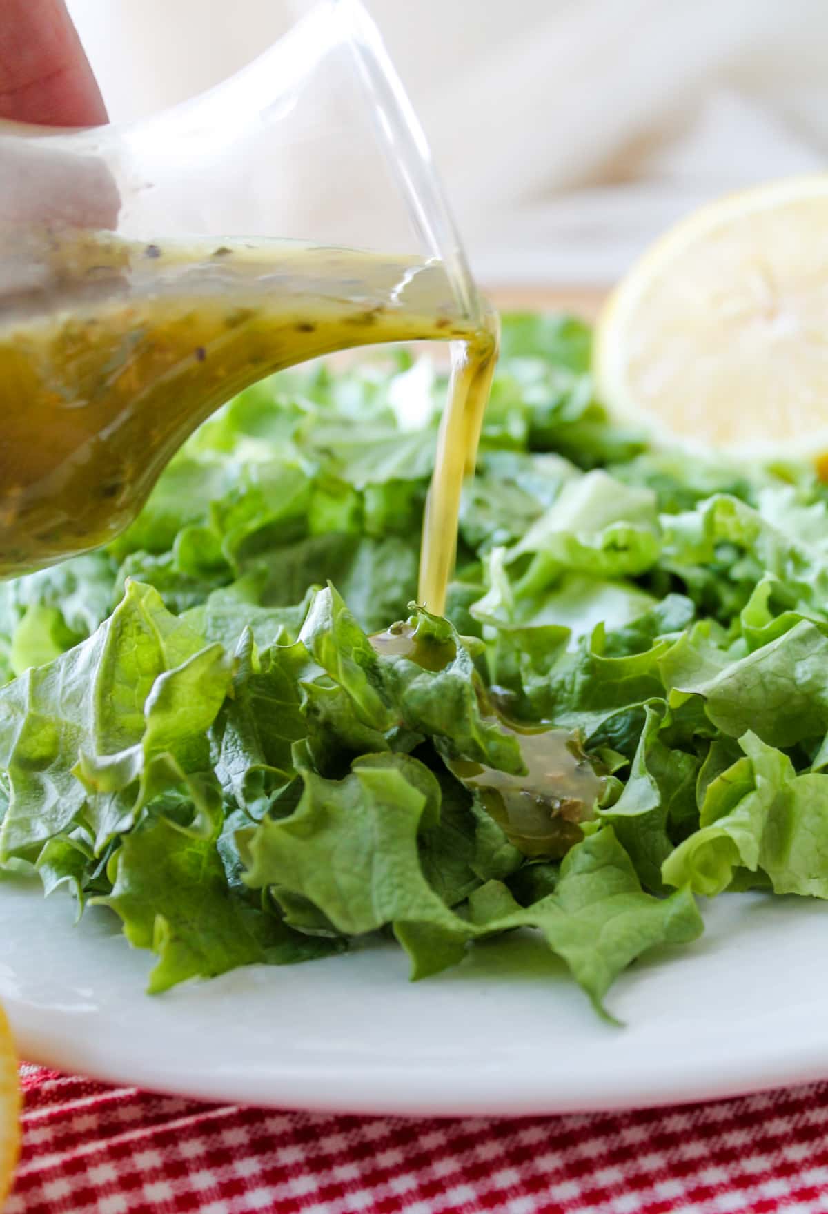 Homemade Italian dressing being poured onto salad.