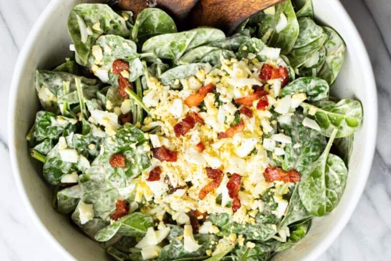 A bowl of Spinach Salad with Bacon and Eggs.