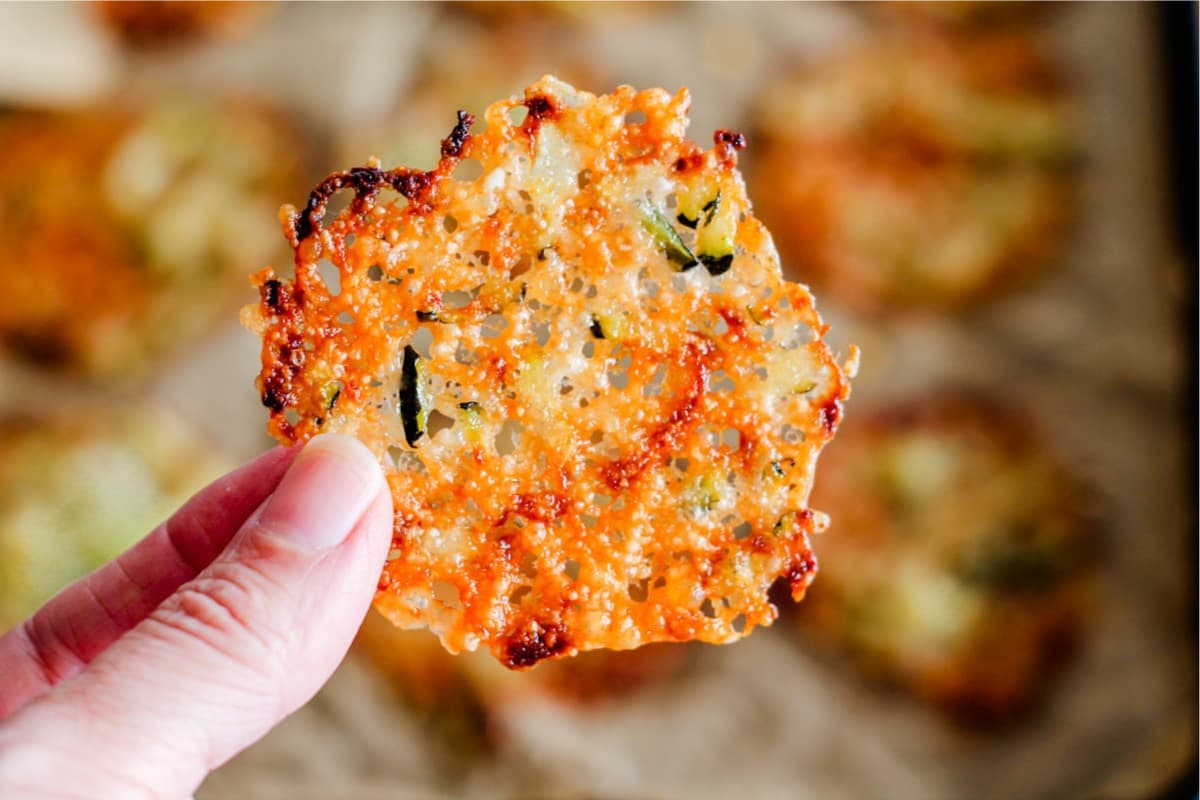 A hand holding Zucchini Parmesan Crisps.