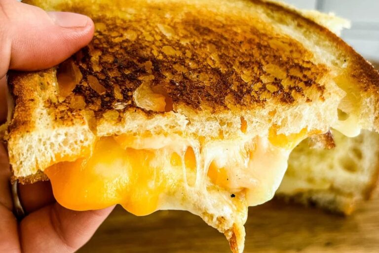 A hand holding Sourdough Grilled Cheese Sandwich.