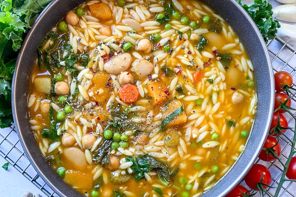 A bowl of Beans and Kale Soup with Kabocha Squash and Orzo.
