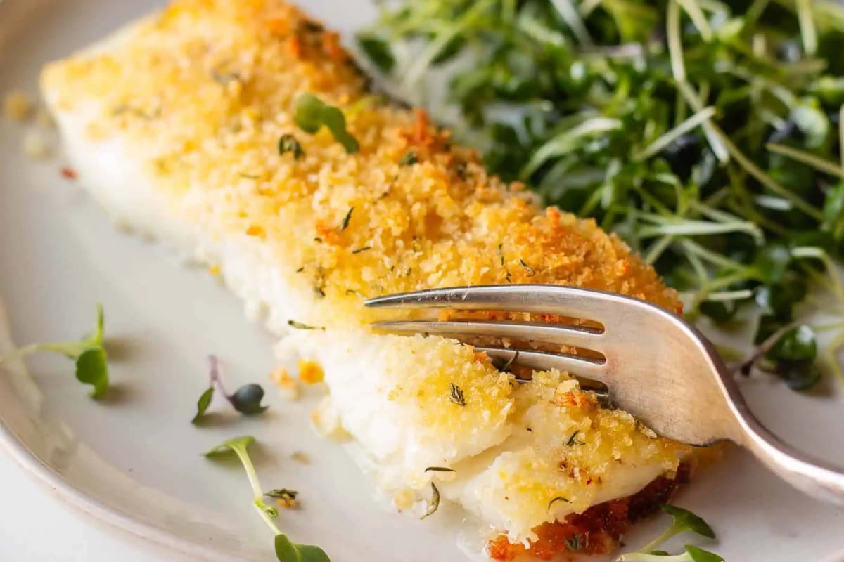 A plate of Baked Sea Bass With Garlic Butter And Herbs.