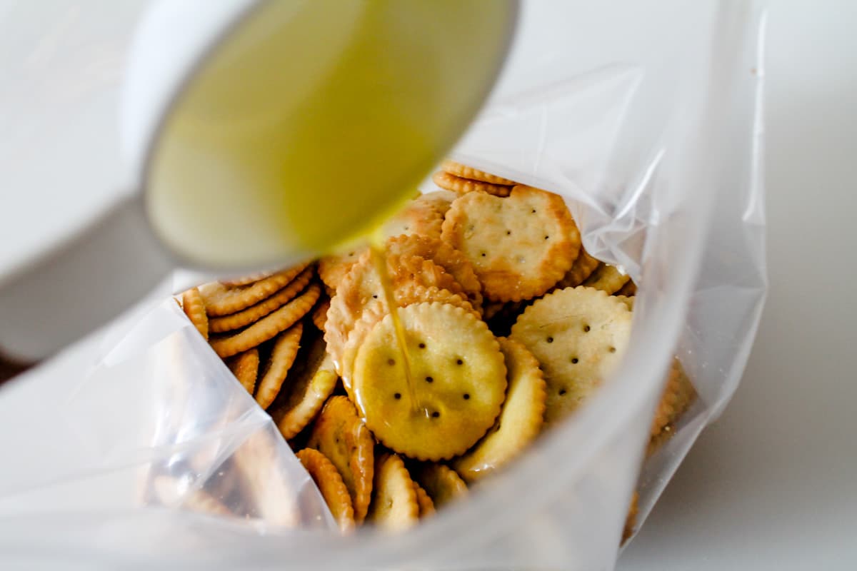 Oil being poured into a bag of crackers.