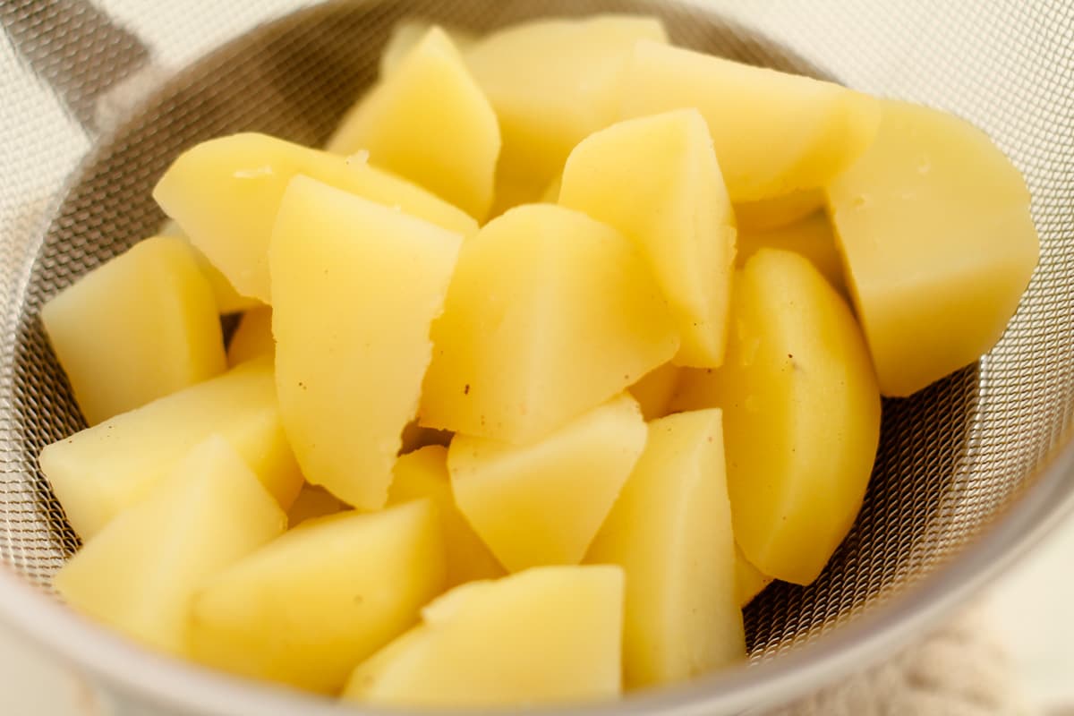 Potatoes draining in a sieve.