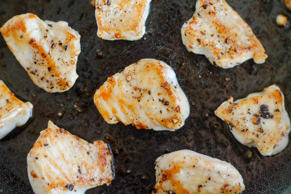 Chicken cooking in a pan.