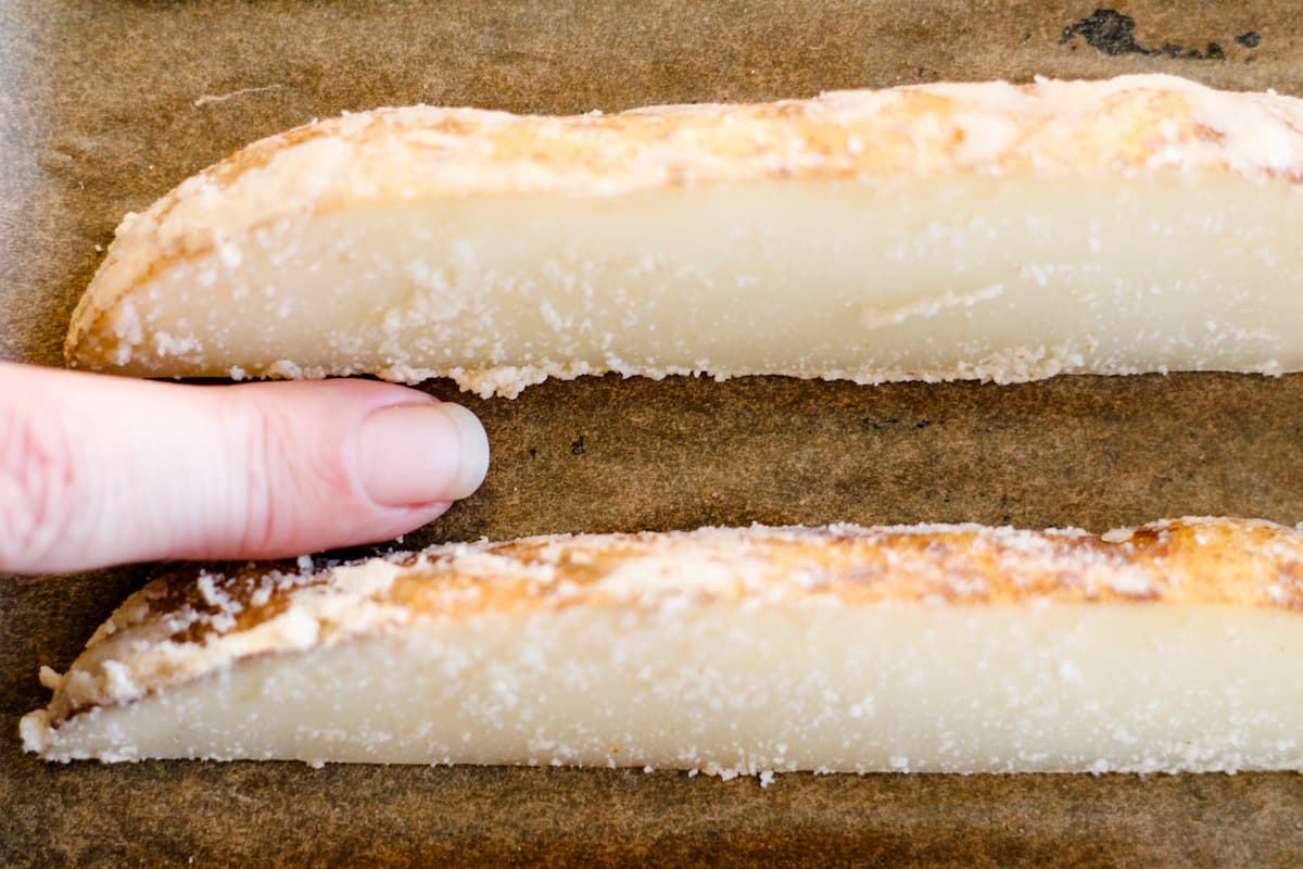 A finger showing the spacing between the potato wedges.