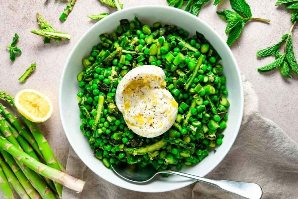 A bowl of Sauteed Asparagus and Peas with Burrata and Mint.