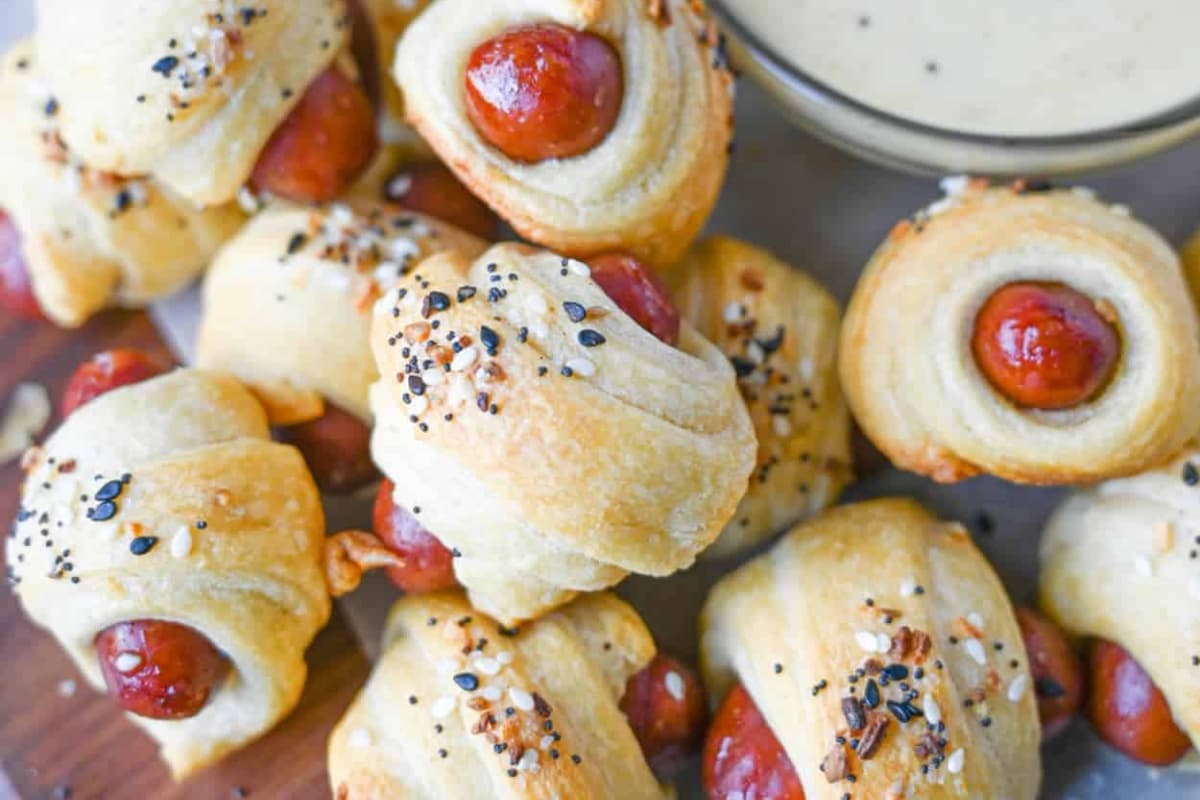 A plate of Pigs in a Blanket with Honey Mustard.