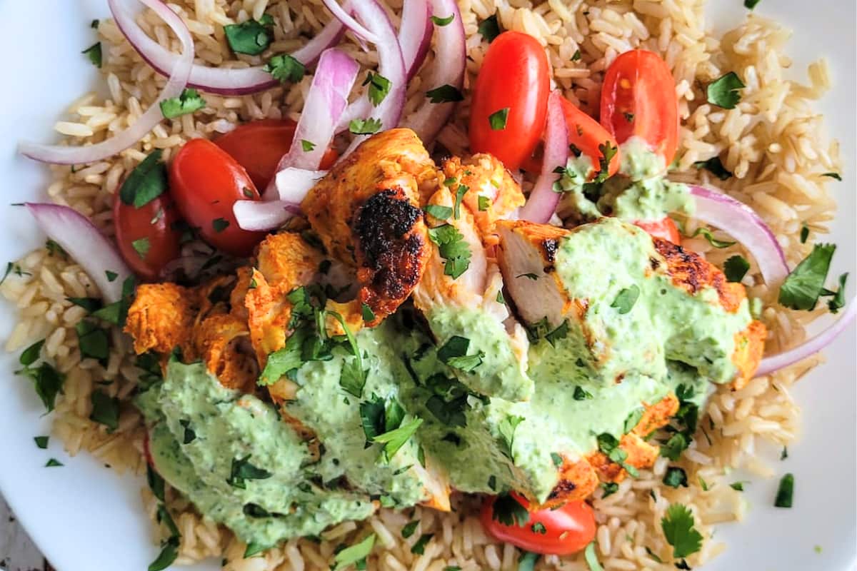 A dish of Chicken Rice Bowl with Greek Yogurt Cilantro Sauce.