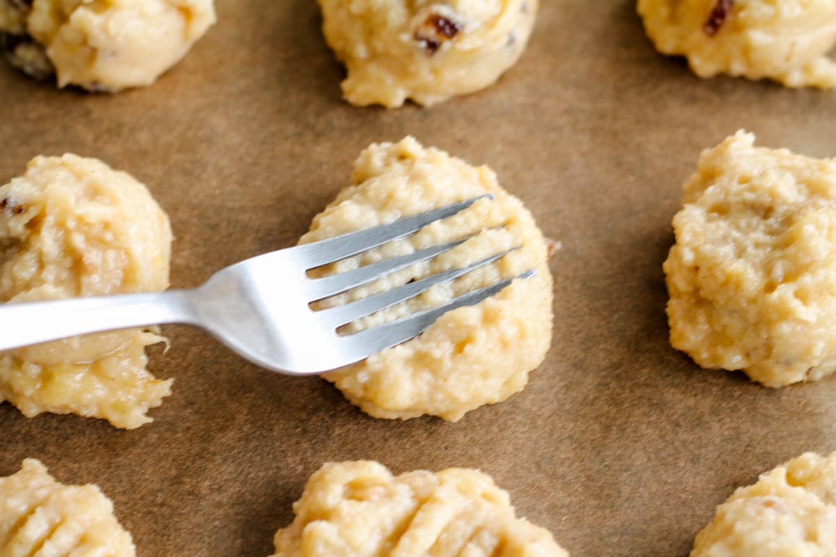 Cookie dough being pressed down with a fork.