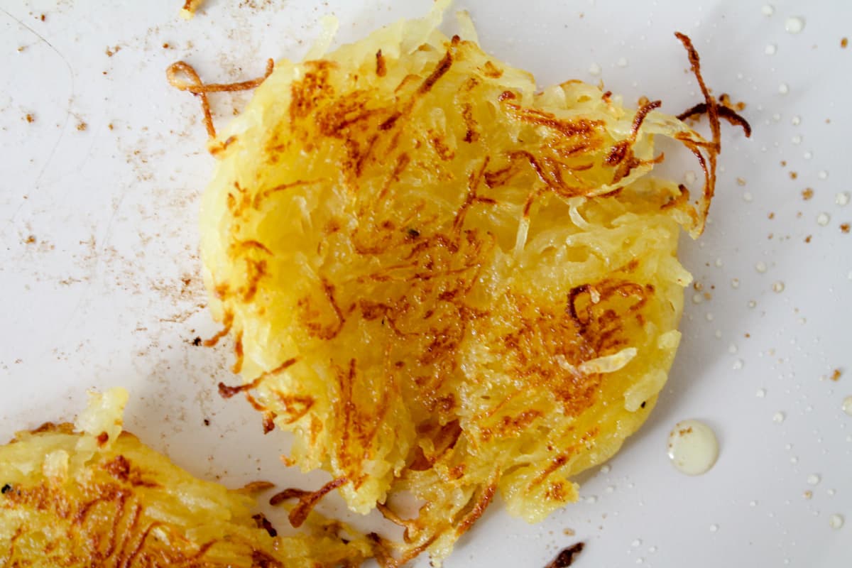 A pan with spaghetti squash hash browns cooking.