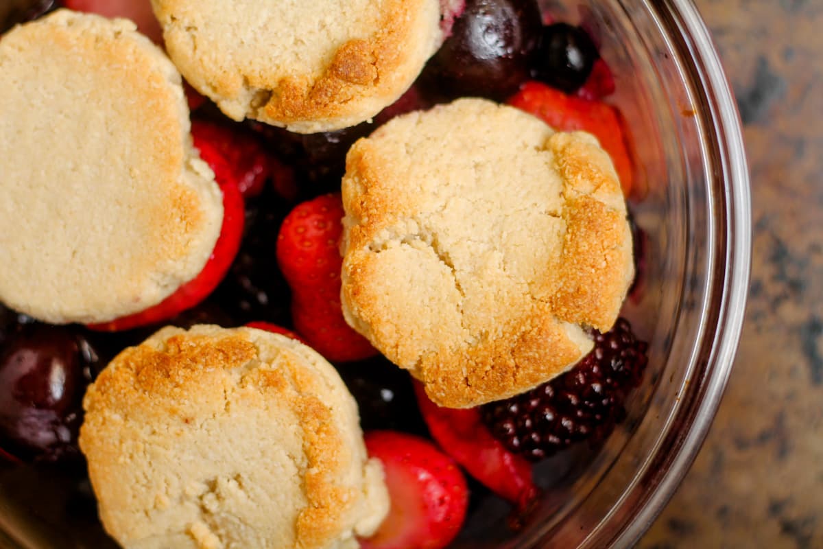 Berries and cookie dough in a dish.