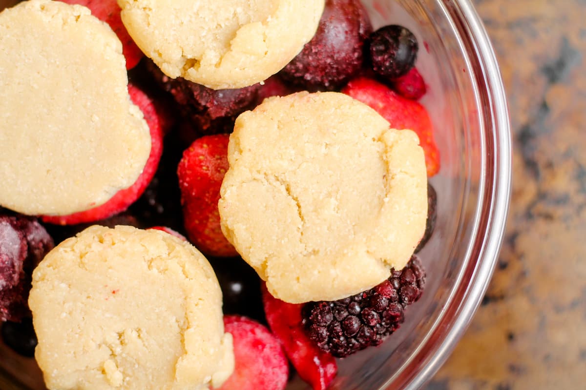 Berries and cookie dough in a dish.