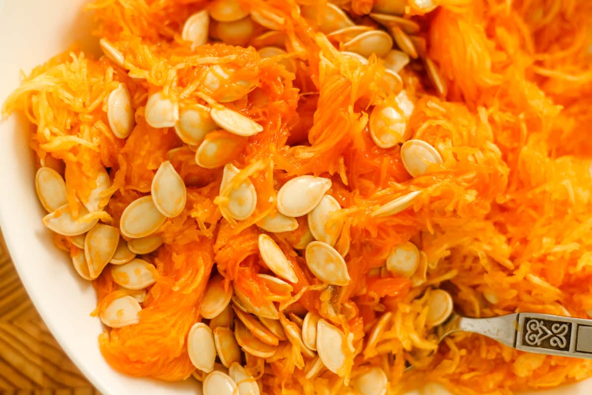 Pumpkin strands and seeds in a bowl.
