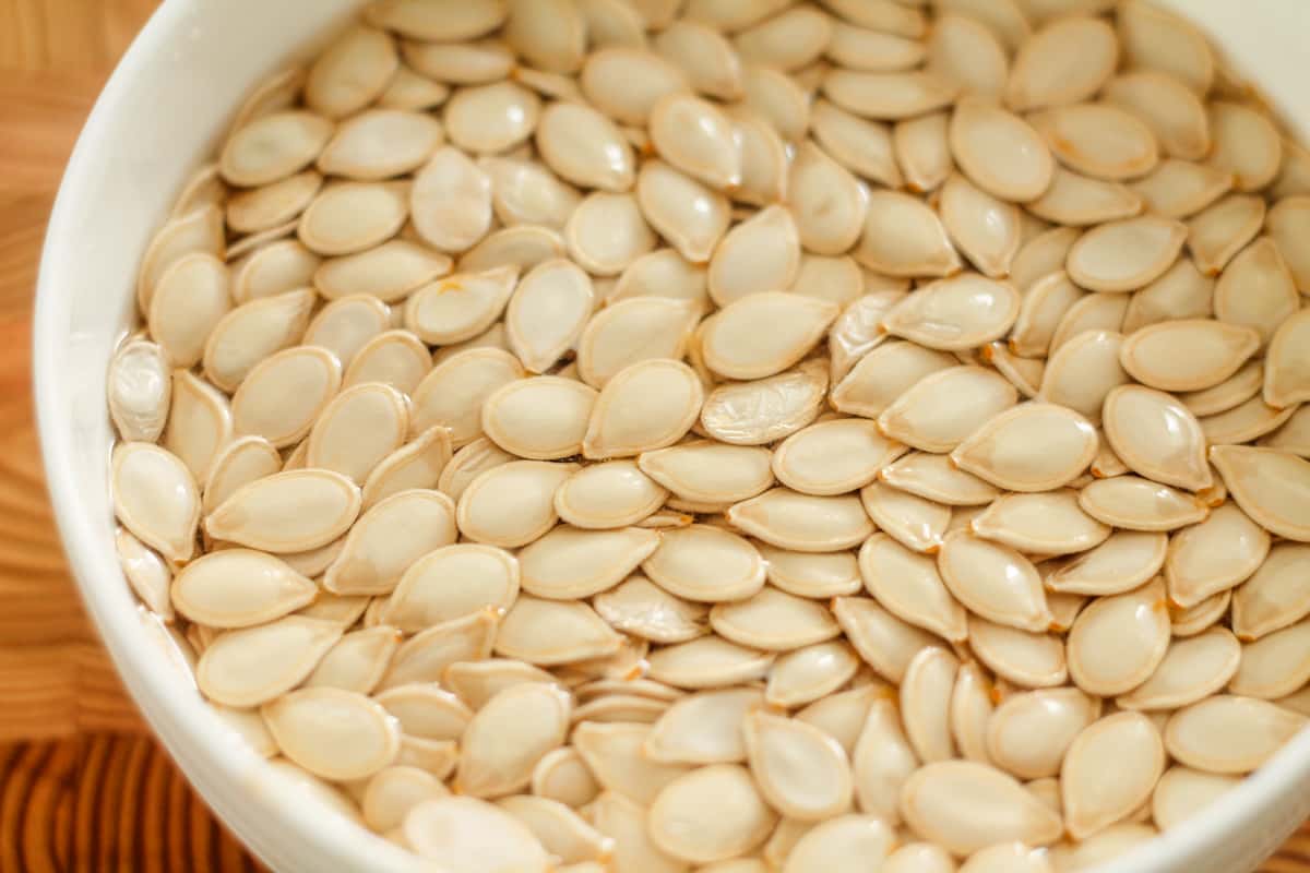 Pumpkin seeds soaking in a bowl.