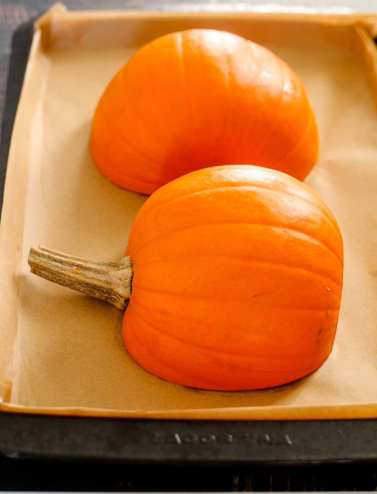 A baking sheet with pumpkins about to be roasted.