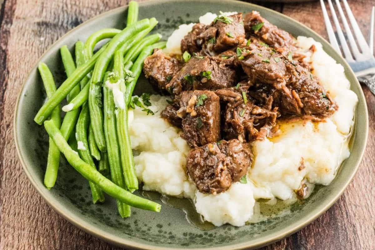 A dish Slow Cooker Garlic Steak Bites.