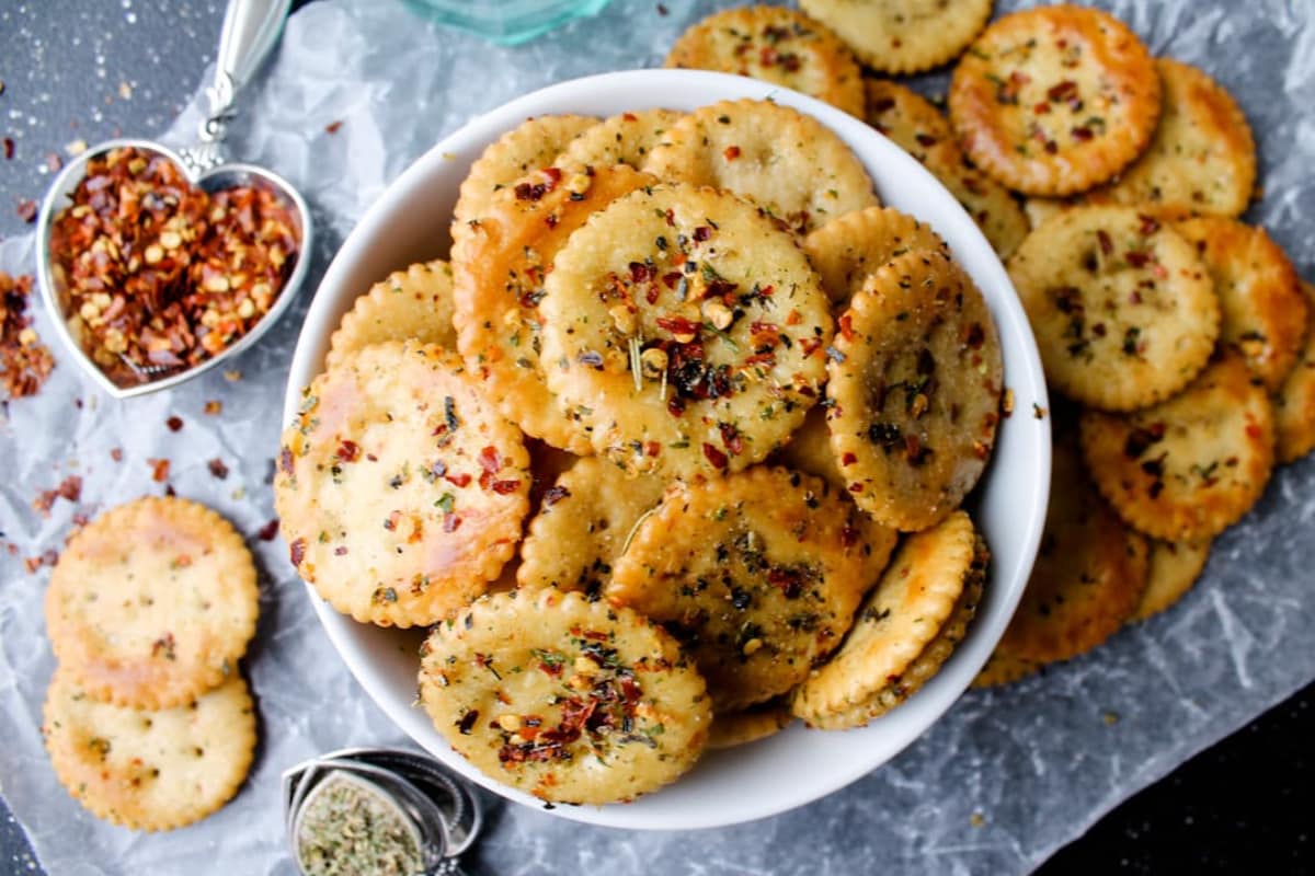 A serving dish of Alabama fire crackers, saltines coated in Italian seasoning and chili flakes.