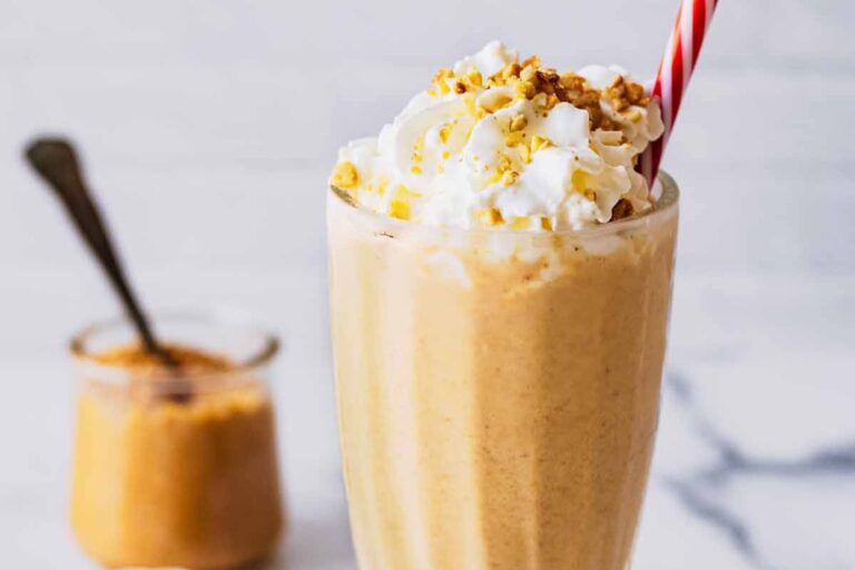 A glass of cold Peanut Butter Milkshake drink.