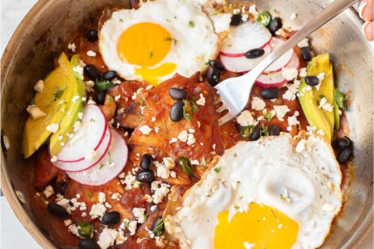 A dish of Chilaquiles Rojos with Fried Eggs.