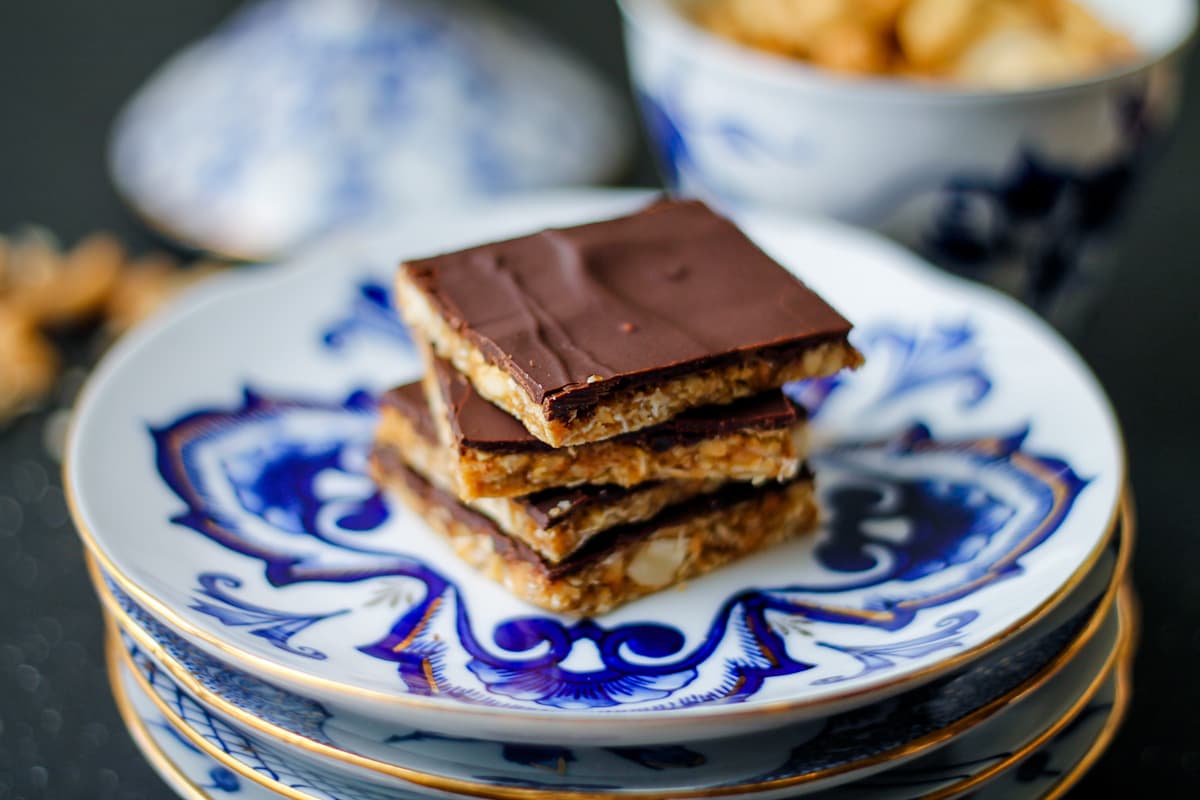 No bake candy bars with a dark chocolate layer on a plate.